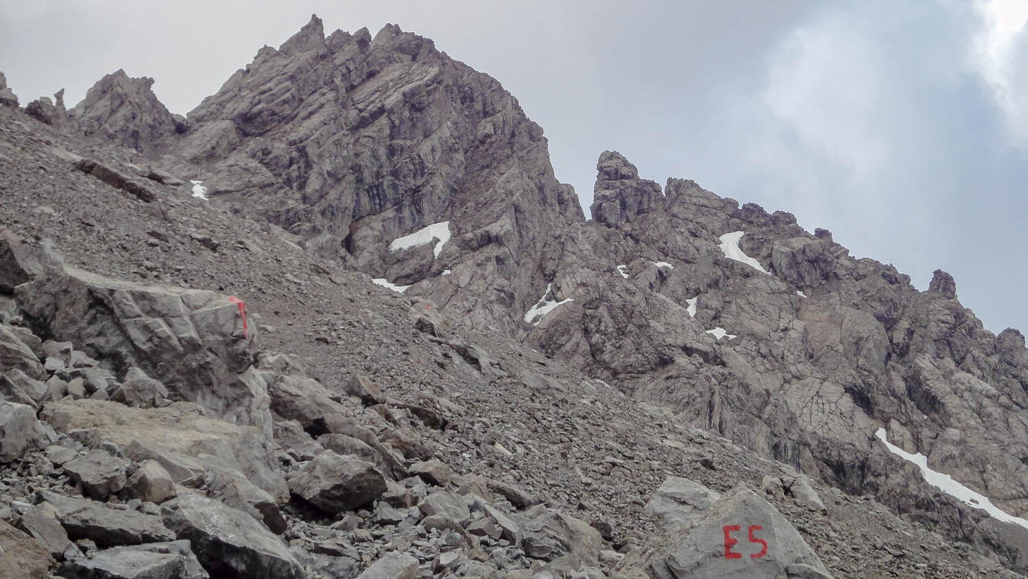 In einem steilen, felsigen Abschnitt auf dem E5 liegt noch letzter Altschnee.
