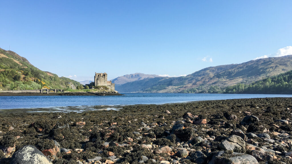 Auf einer kleinen Insel, verbunden mit dem Festland durch eine kleine Brücke, ist eine Burg: Eilean Donan Castle in Schottland.