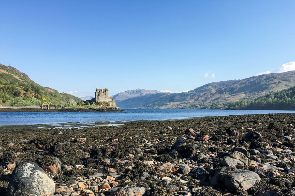 Auf einer kleinen Insel, verbunden mit dem Festland durch eine kleine Brücke, ist eine Burg: Eilean Donan Castle in Schottland.